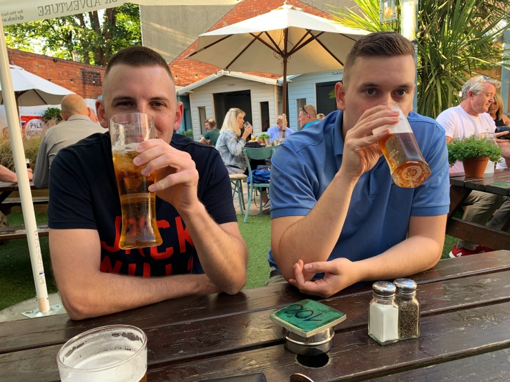 Two guys drinking beer from pint glasses